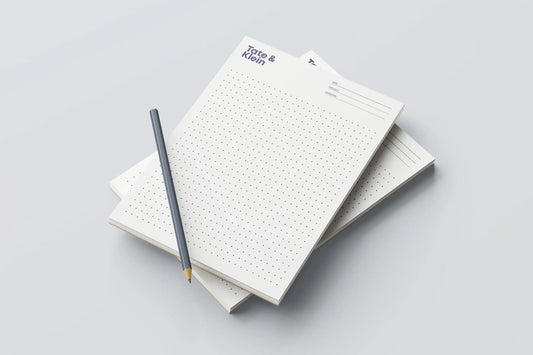 Minimalist dotted notepad stack with pencil on light background, custom print design