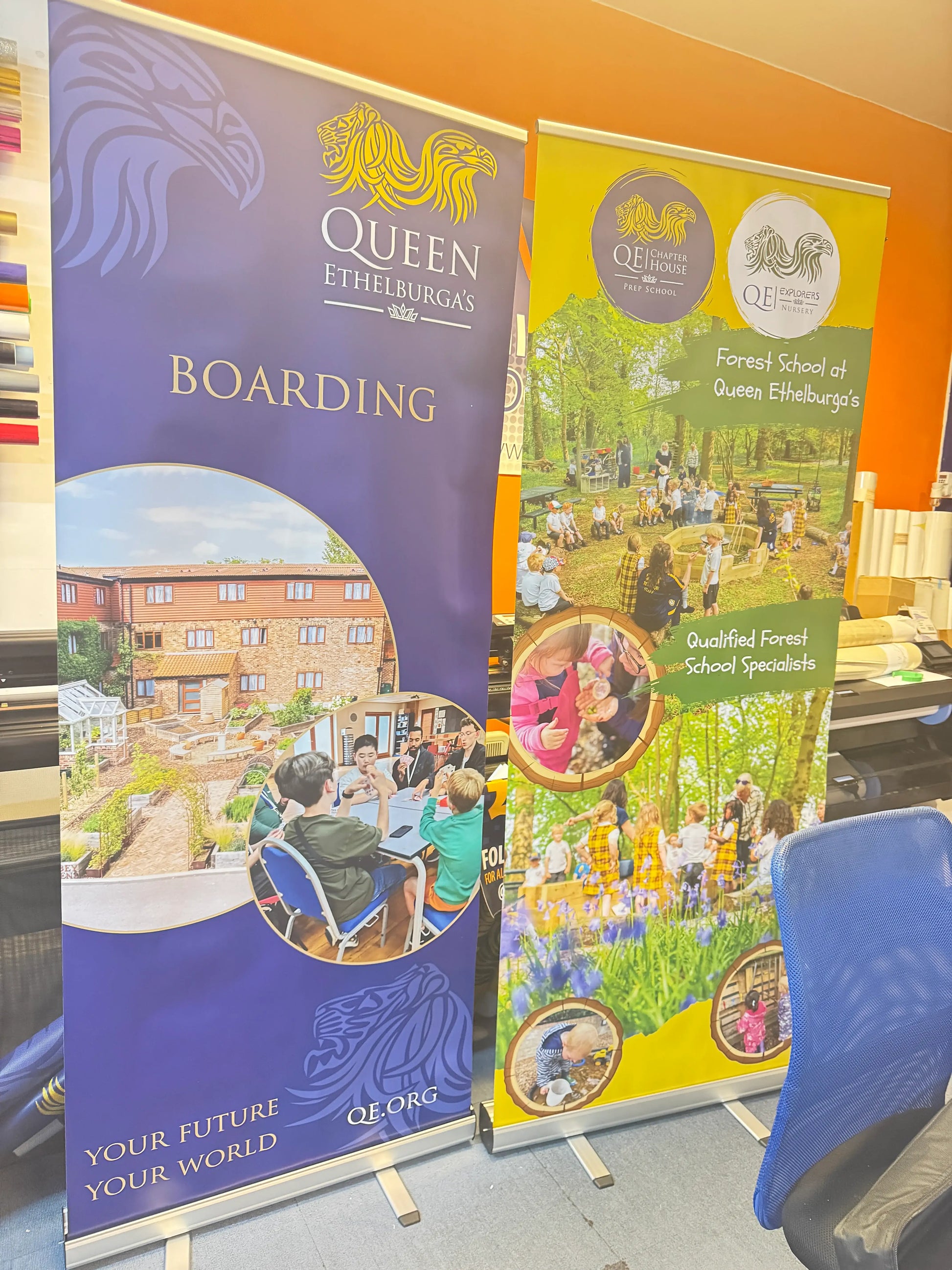 Colorful printed banners for Queen Ethelburga’s school and forest school displayed indoors