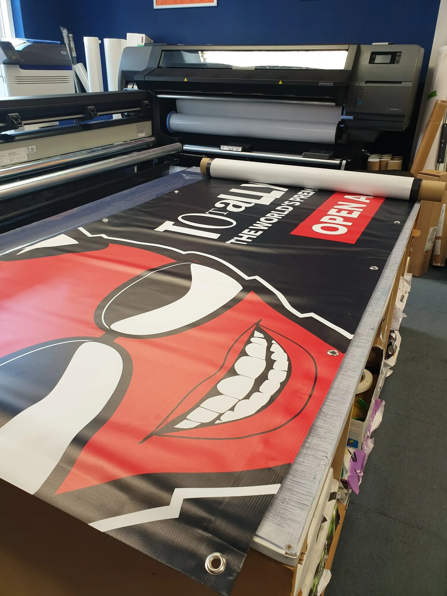 Large format banner with bold print and cartoon face in a professional print shop
